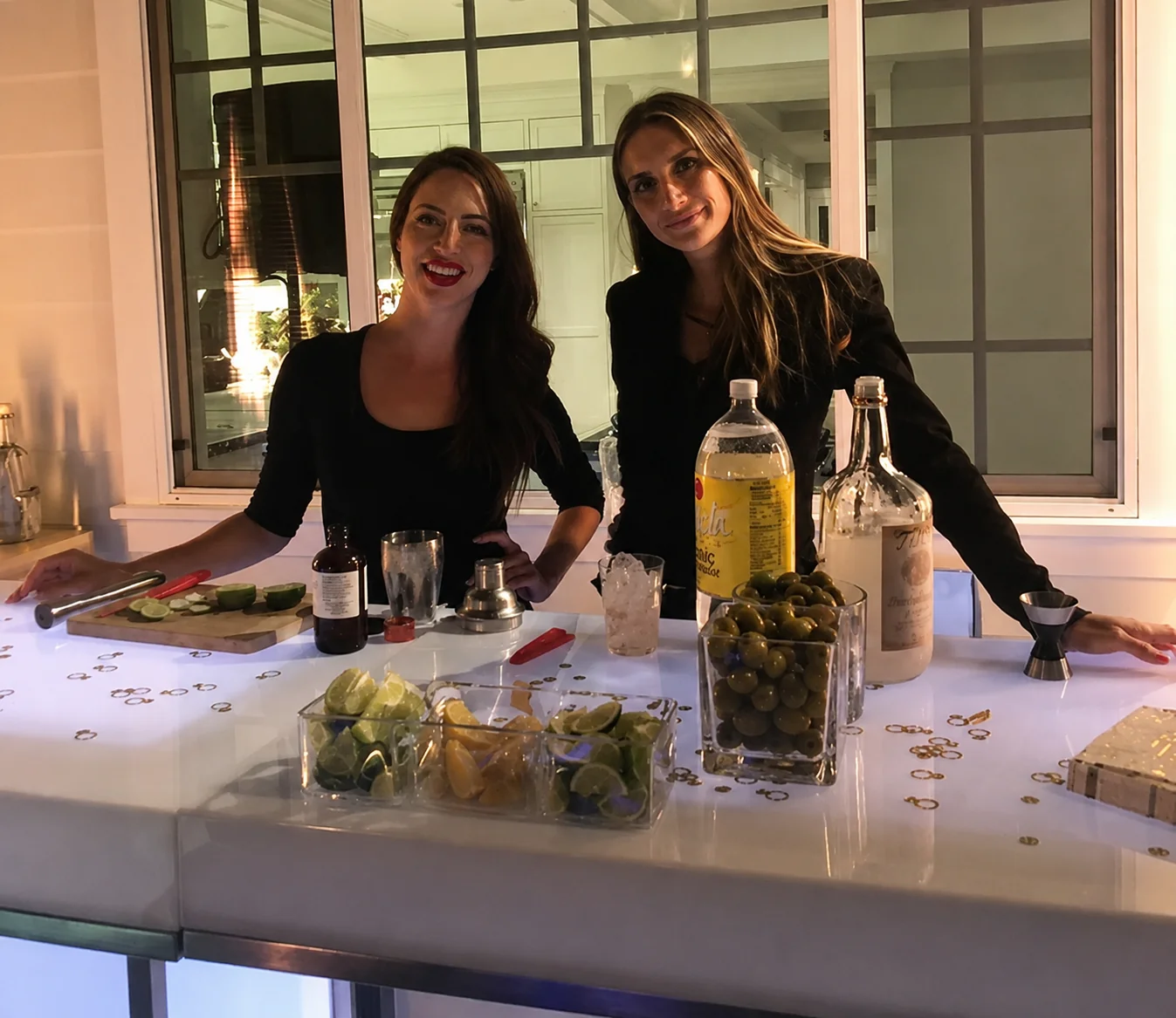 Two professional SoCal Bartender event bartenders at a white-lit LED bar with fresh garnishes
